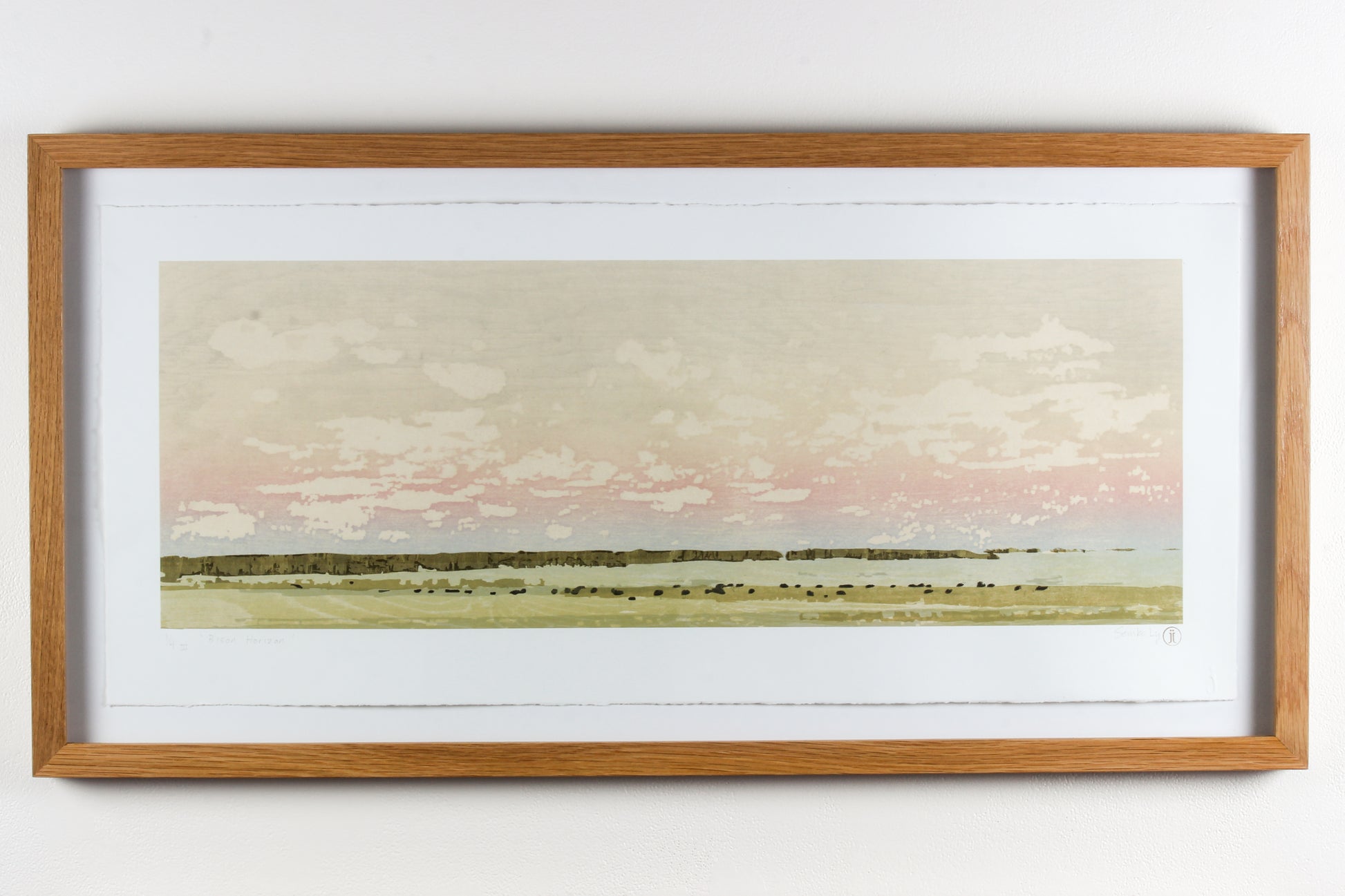 Framed wood print landscape of a soft pink sky and a field of grazing bison.