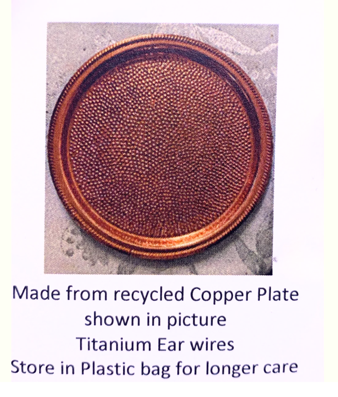A round copper-colored plate with a textured, beaded edge, shown on a light background with descriptive text below stating it is made from recycled copper plate and titanium ear wires.
