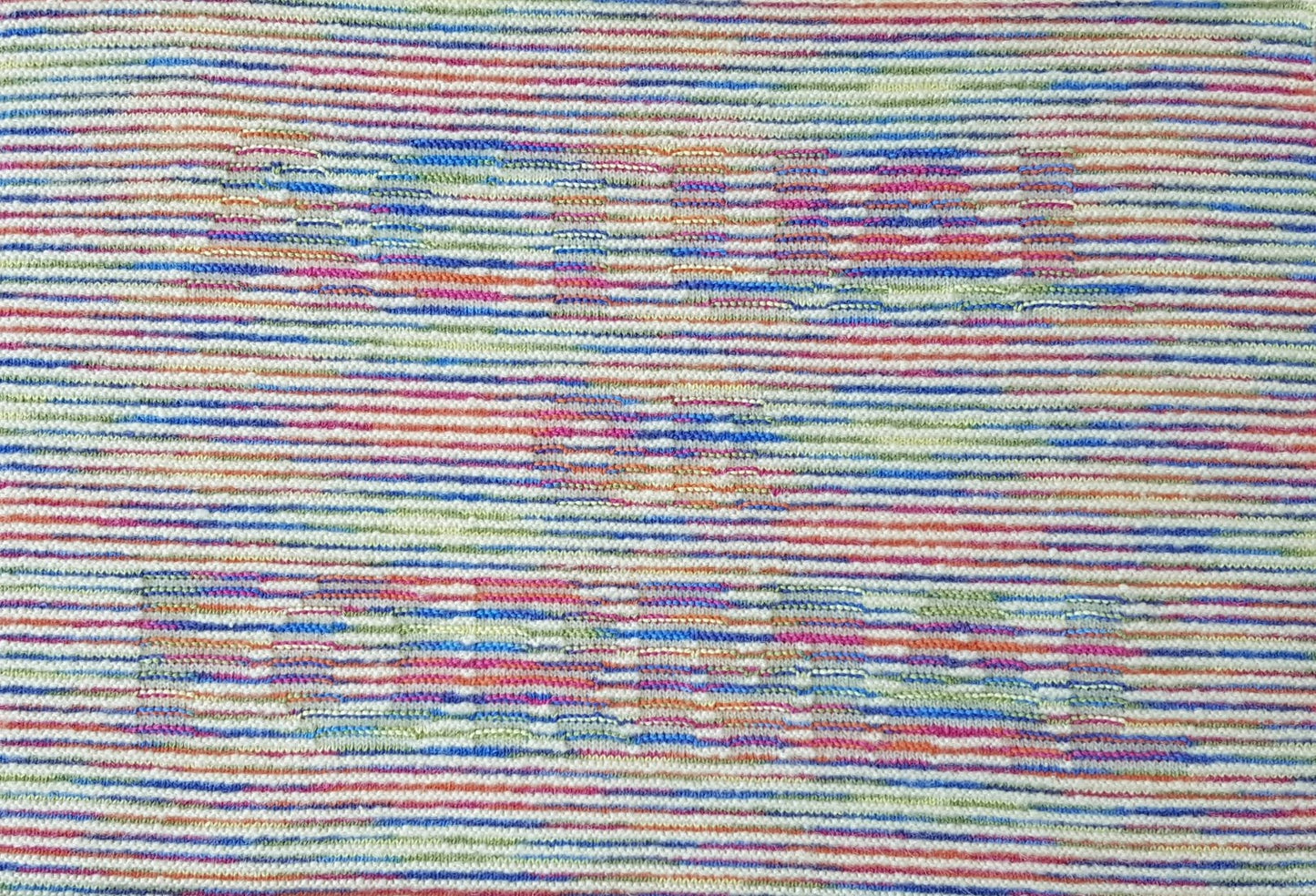 Knitted wall hanging in cream and rainbow gradient yarn. Text: ACTUAL OR FORMAL