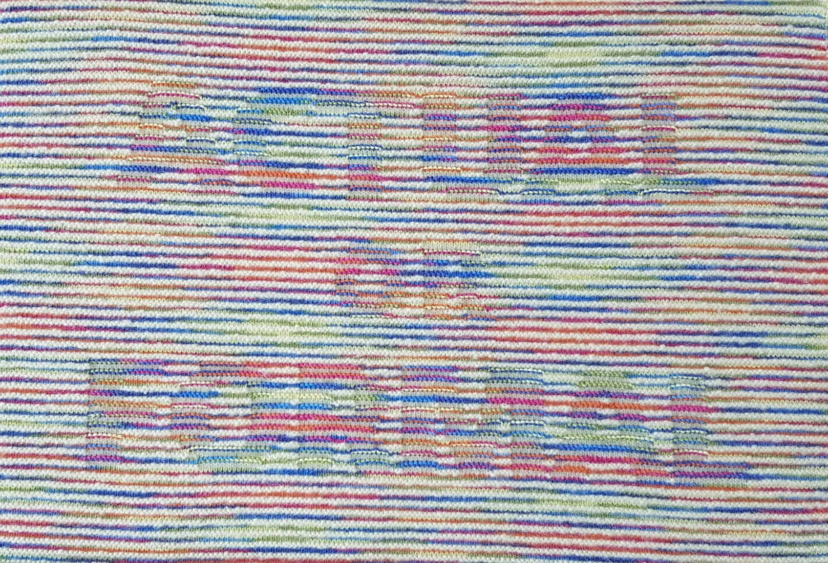 Knitted wall hanging in cream and rainbow gradient yarn. Text: ACTUAL OR FORMAL