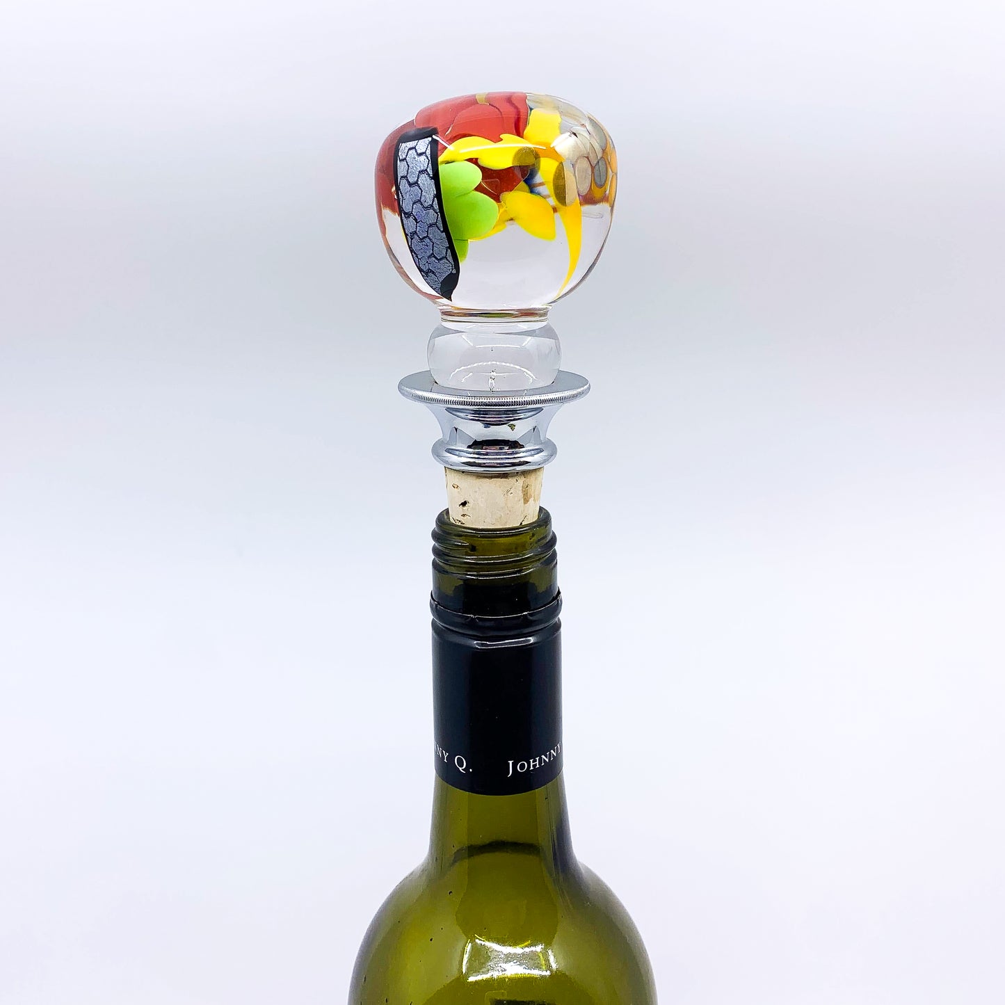 Red, yellow, green wine stopper in wine bottle