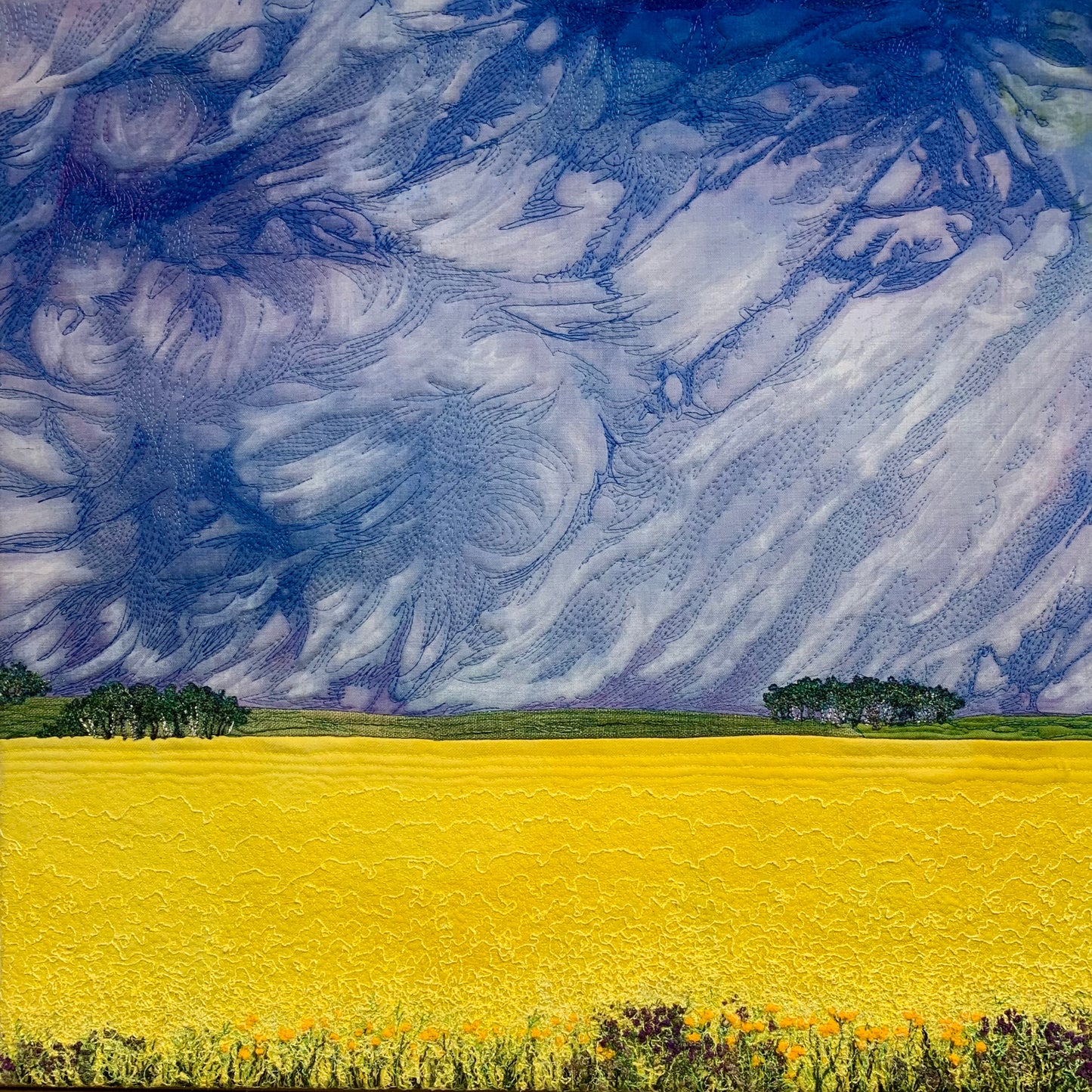 Embroidered painting of a canola field under a dark sky
