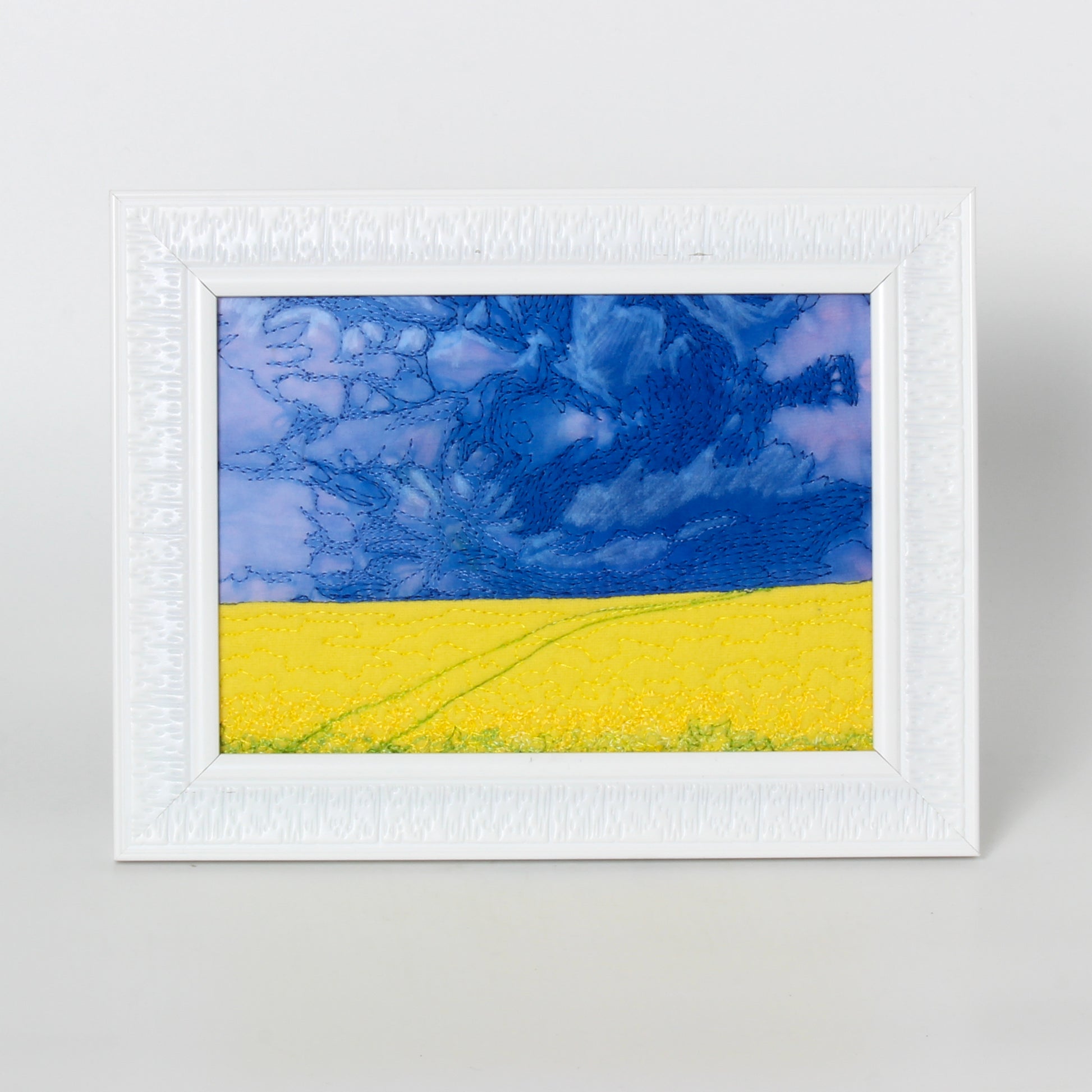 prairie thread painting of canola field and trail