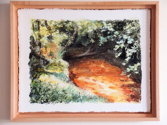 Framed artwork of a forest path with a wooden frame.