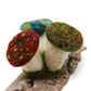 Red, blue, and green mushrooms on driftwood