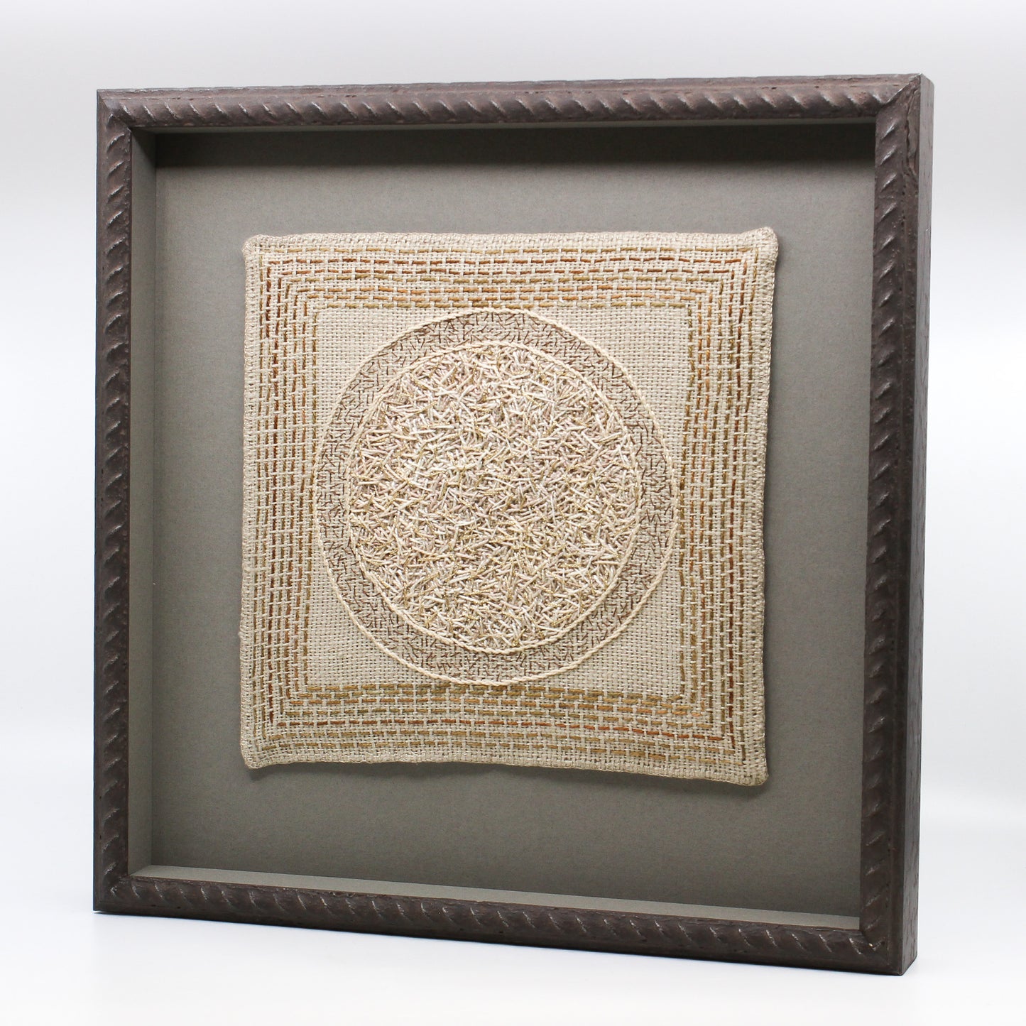 Circle embroidered on linen in frame