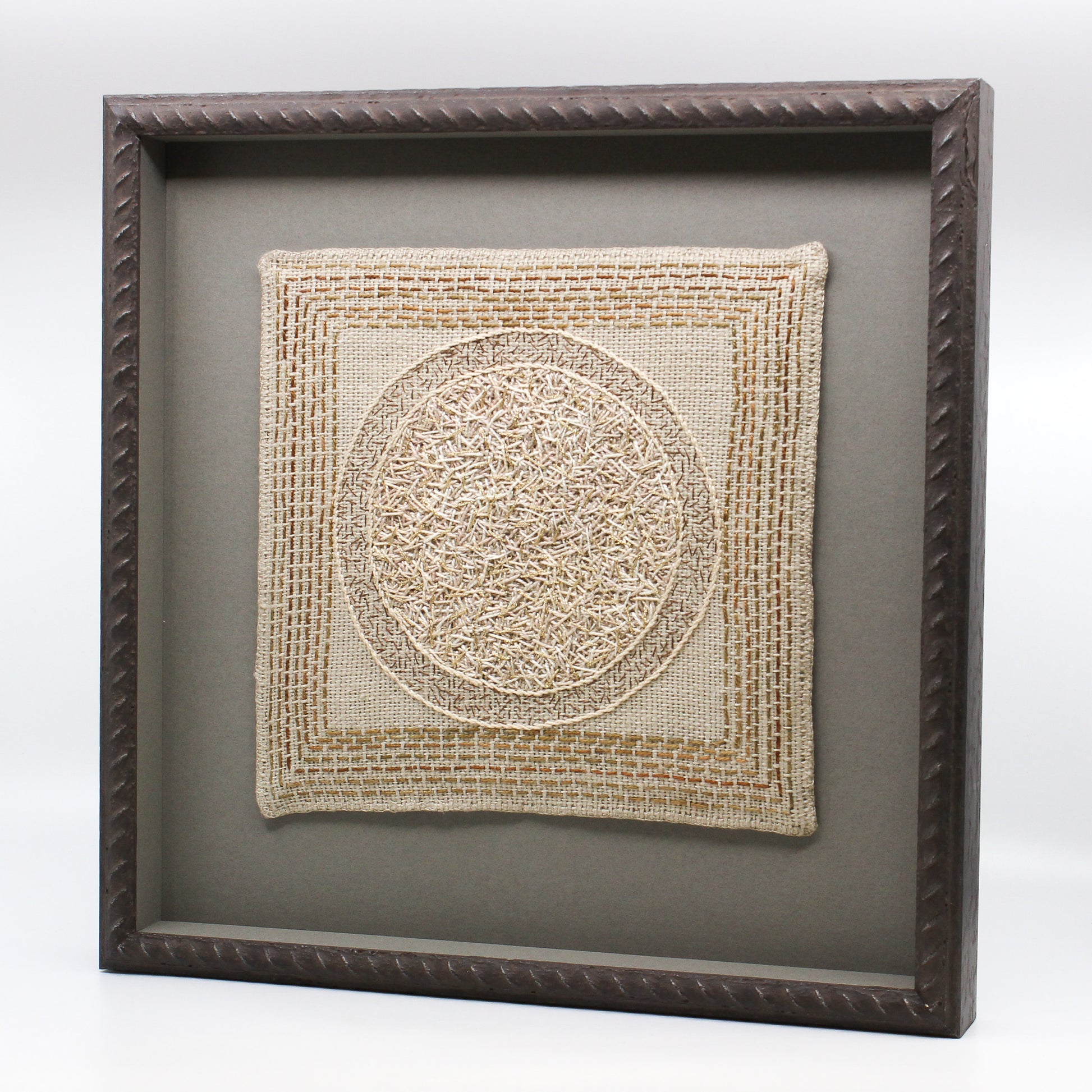 Circle embroidered on linen in frame