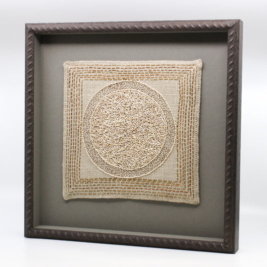Circle embroidered on linen in frame