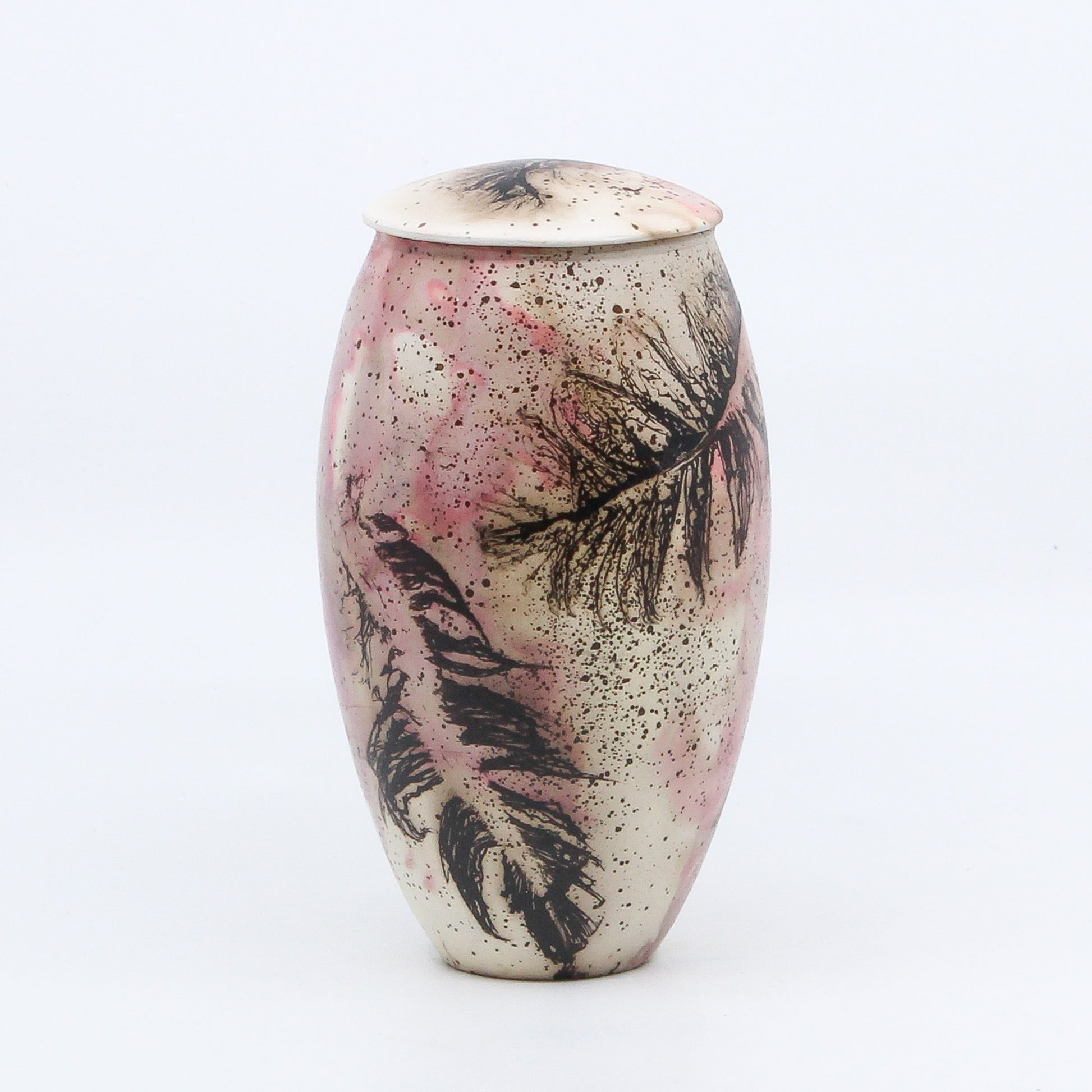 pink lidded vase with burnt feathers