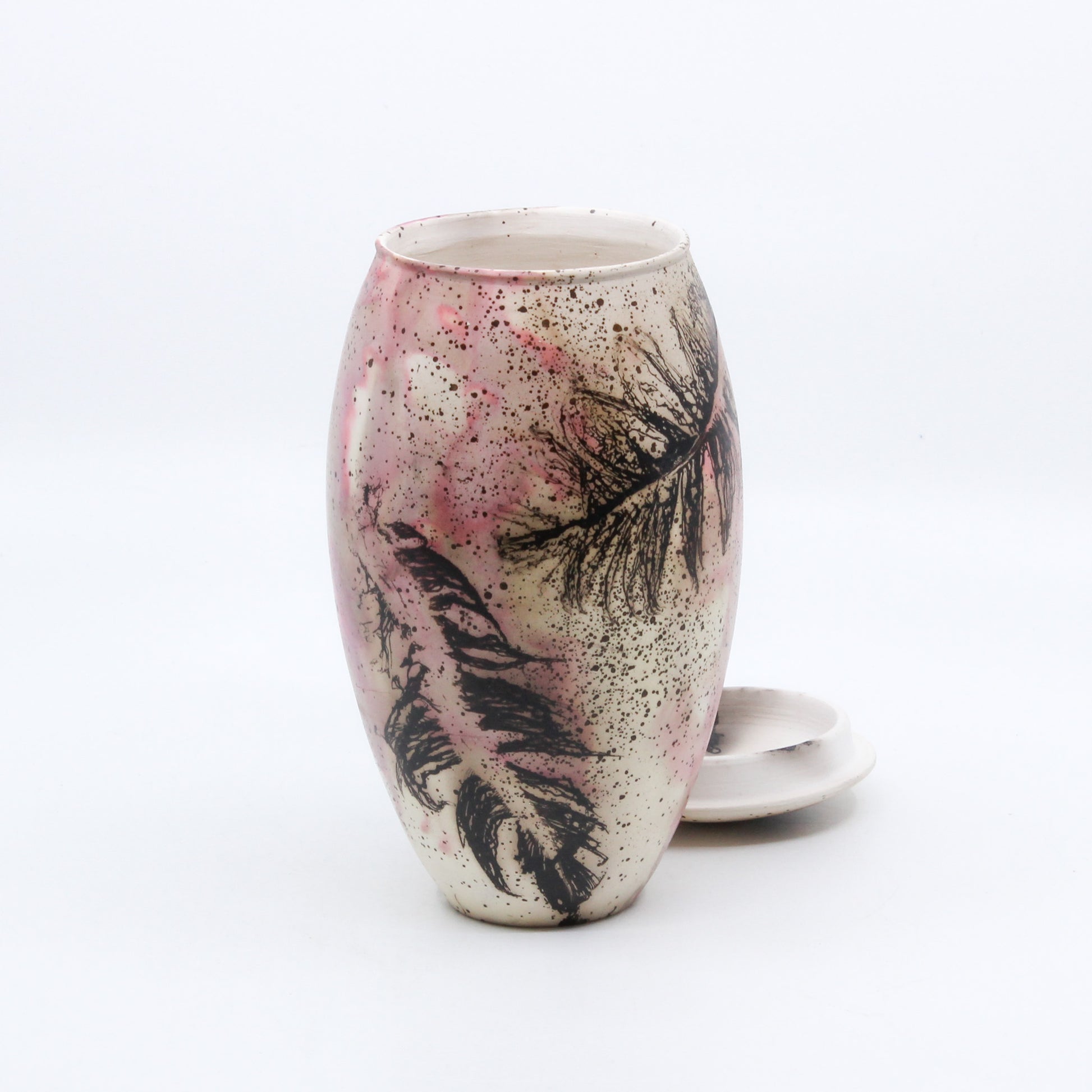 pink vase with lid with burnt feathers