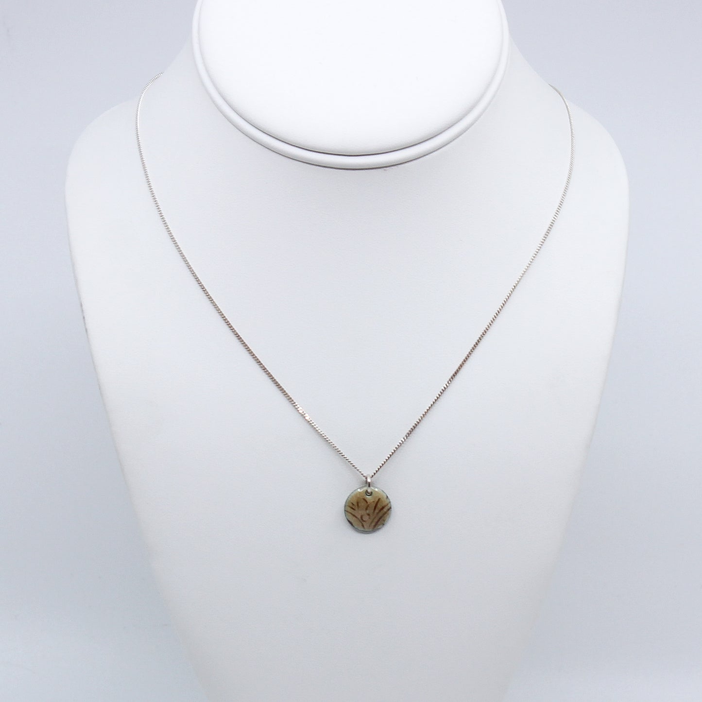 Cream enamel necklace on mannequin