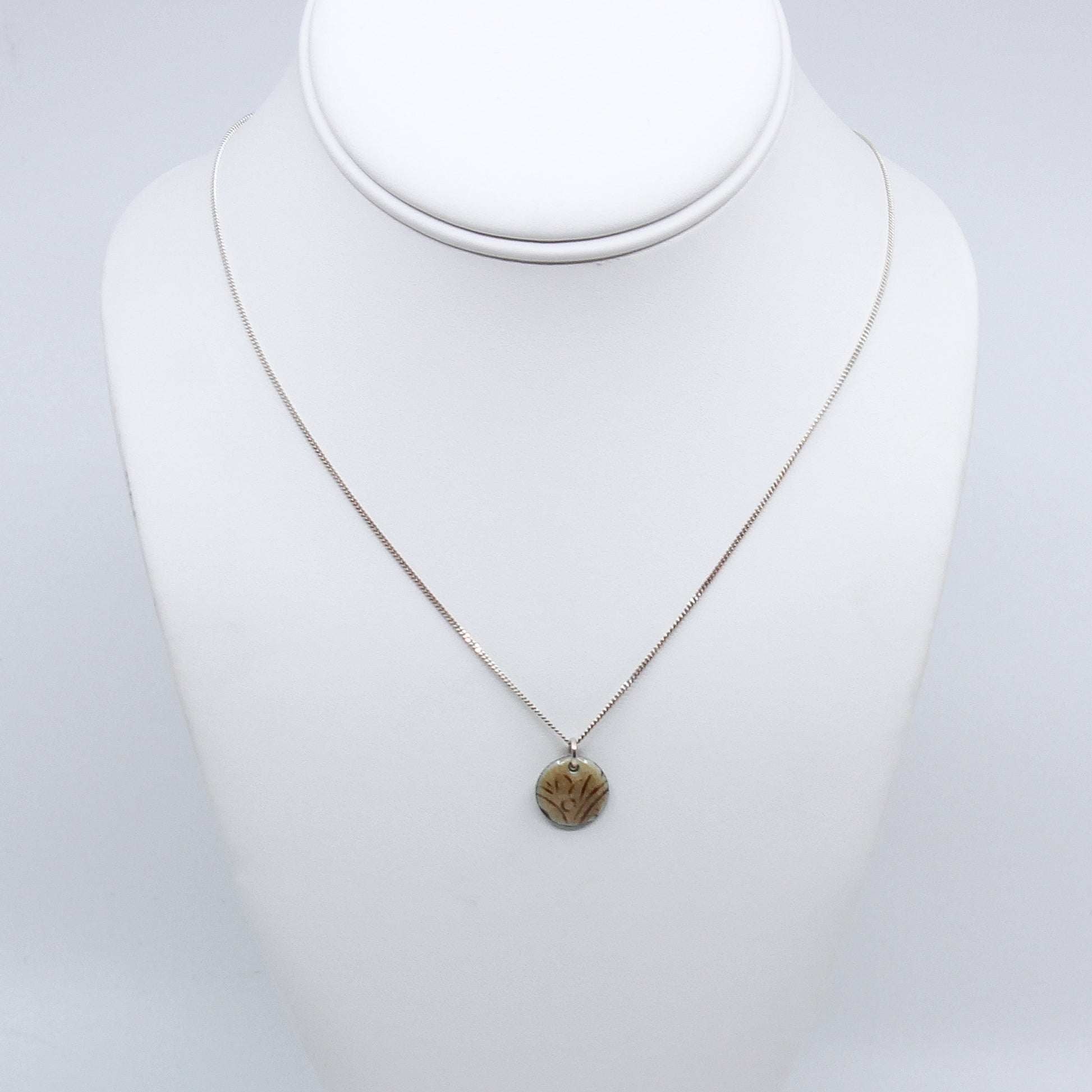 Cream enamel necklace on mannequin