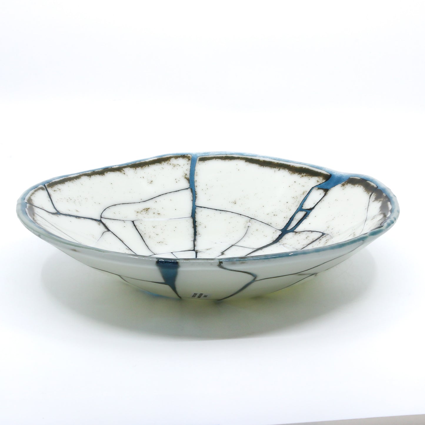 Cracked opaque white bowl filled in with transparent blue glass