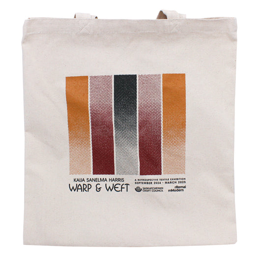 A beige canvas tote bag featuring artwork by Kaija Sanelma Harris and the logo for her retrospective exhibition "Warp & Weft"