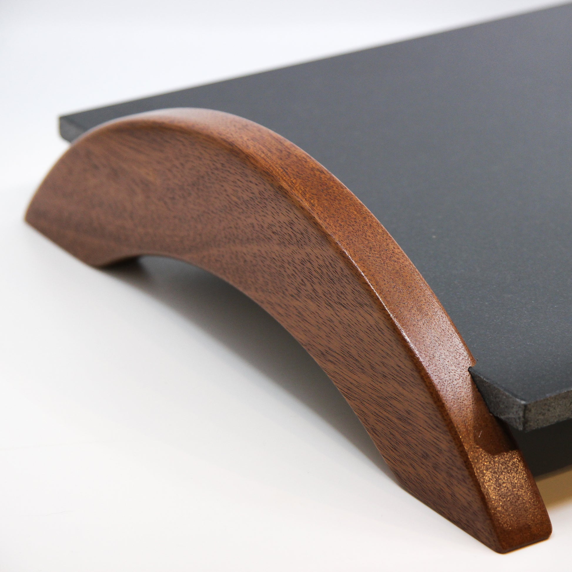 Close up of wooden handles on black stone tray