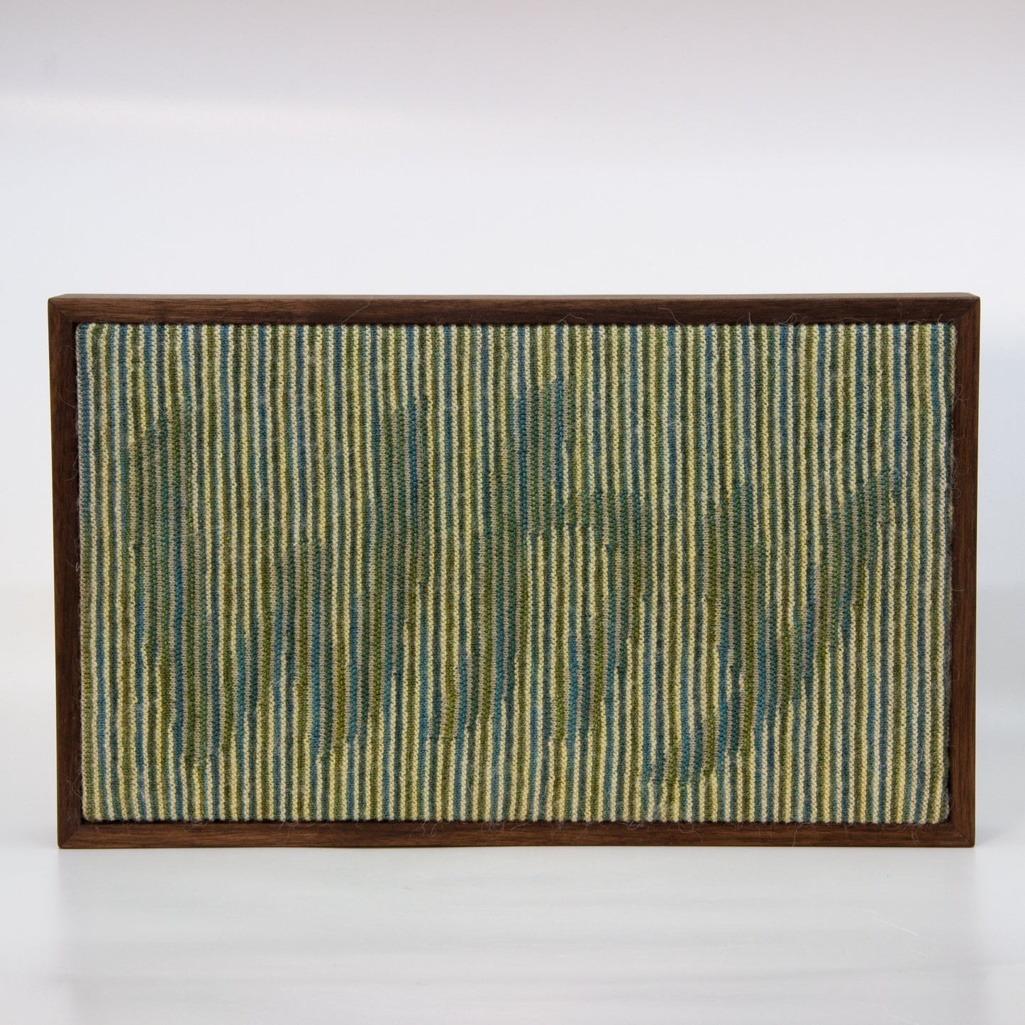 Binary knitted wall hanging with cream blue and green yarn. Text: Why