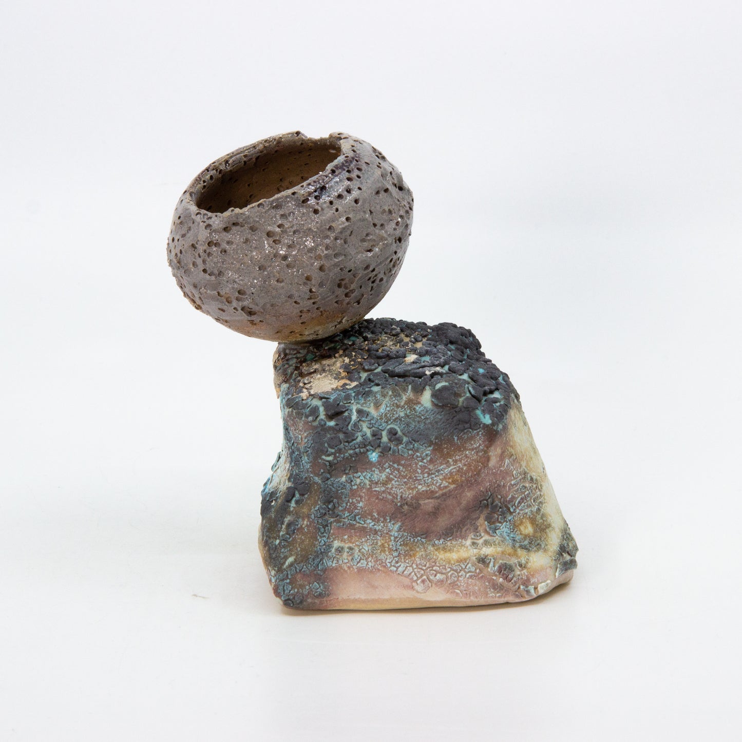 textured clay pot on top of rock