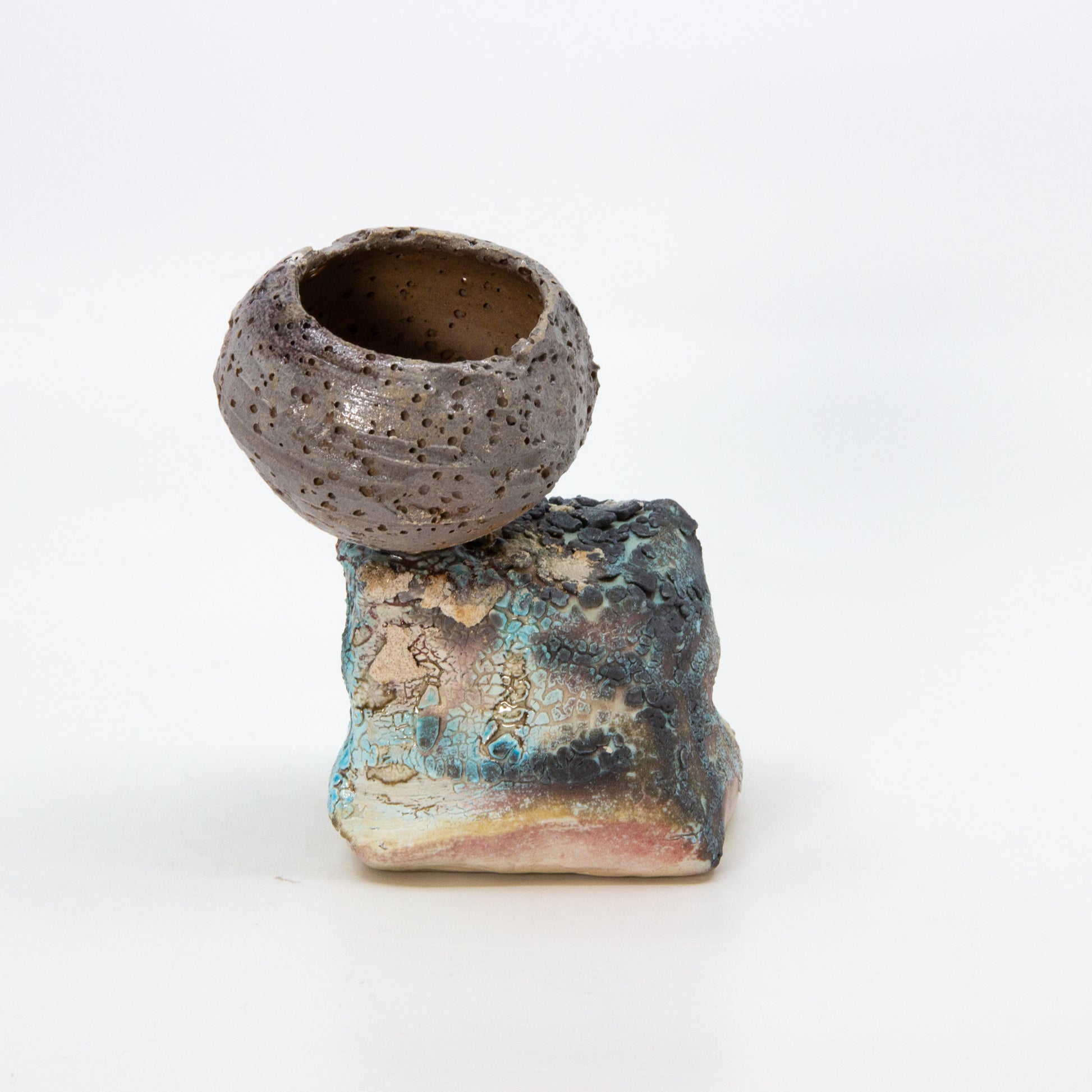 textured clay pot on top of rock