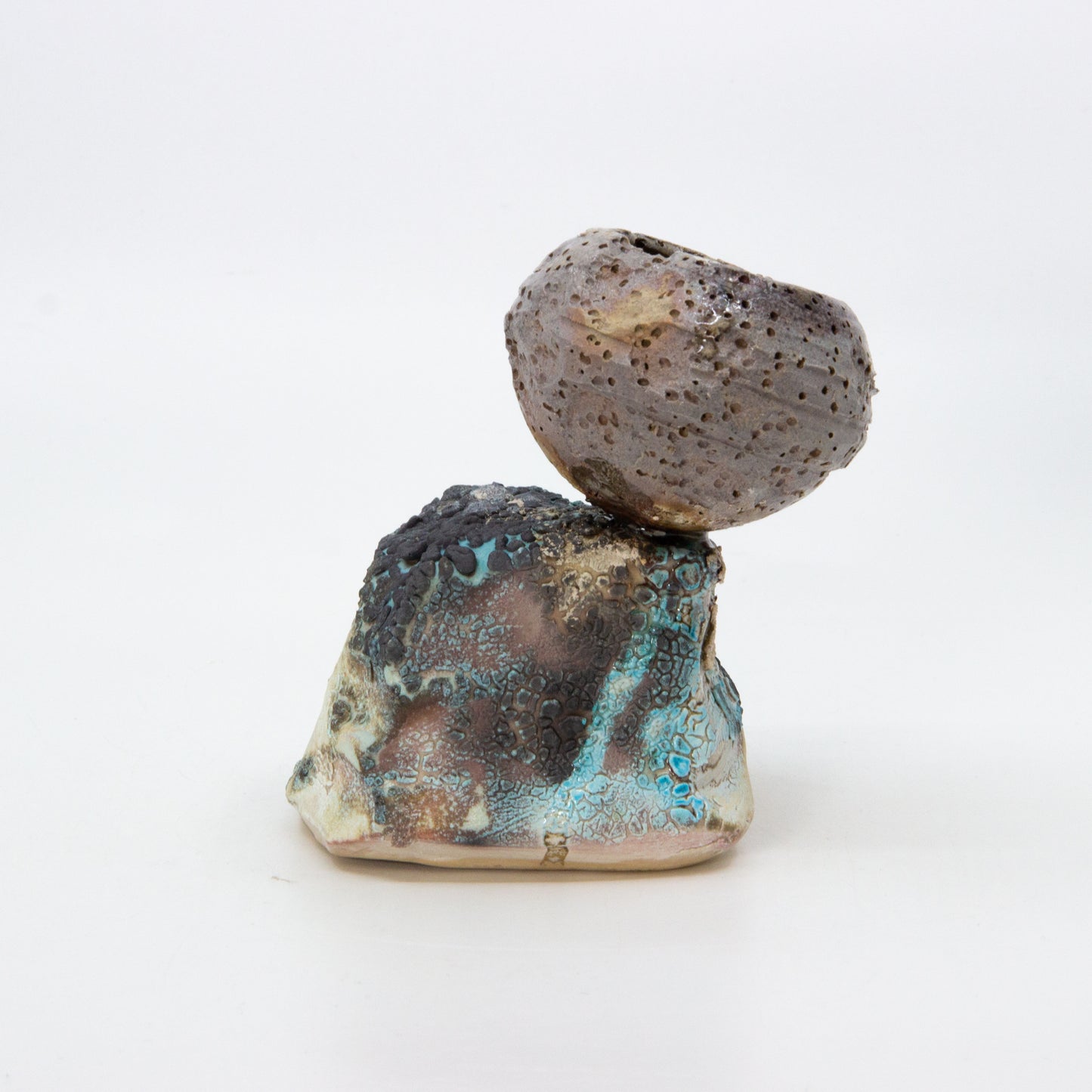 textured clay pot on top of rock