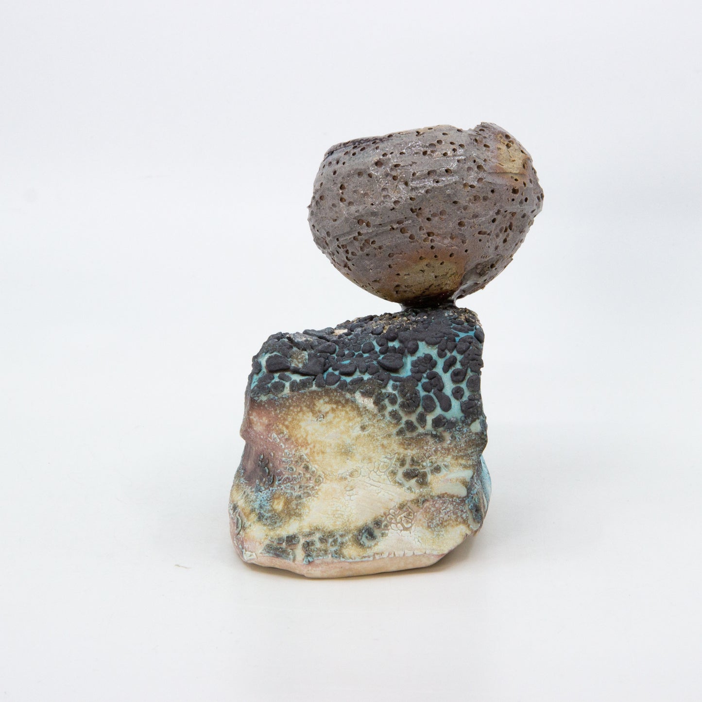 textured clay pot on top of rock