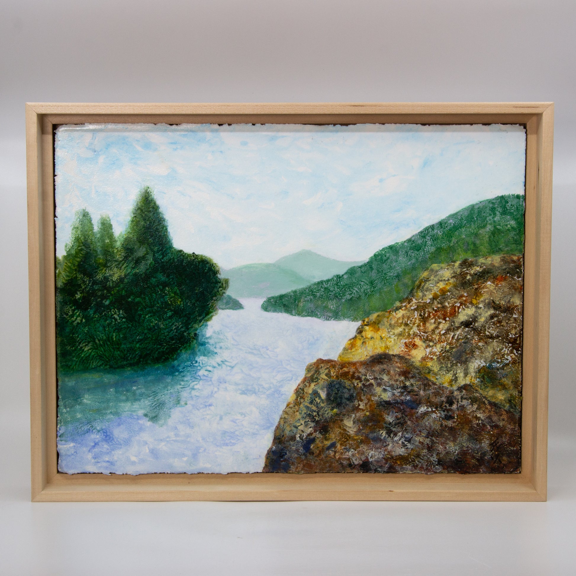 Monotype print of a rive between trees and mountains