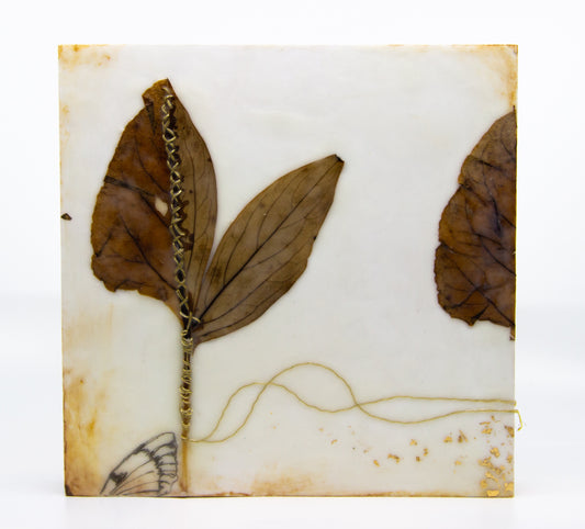 Natural coloured encaustic with leaves, golden thread, and butterfly wing 