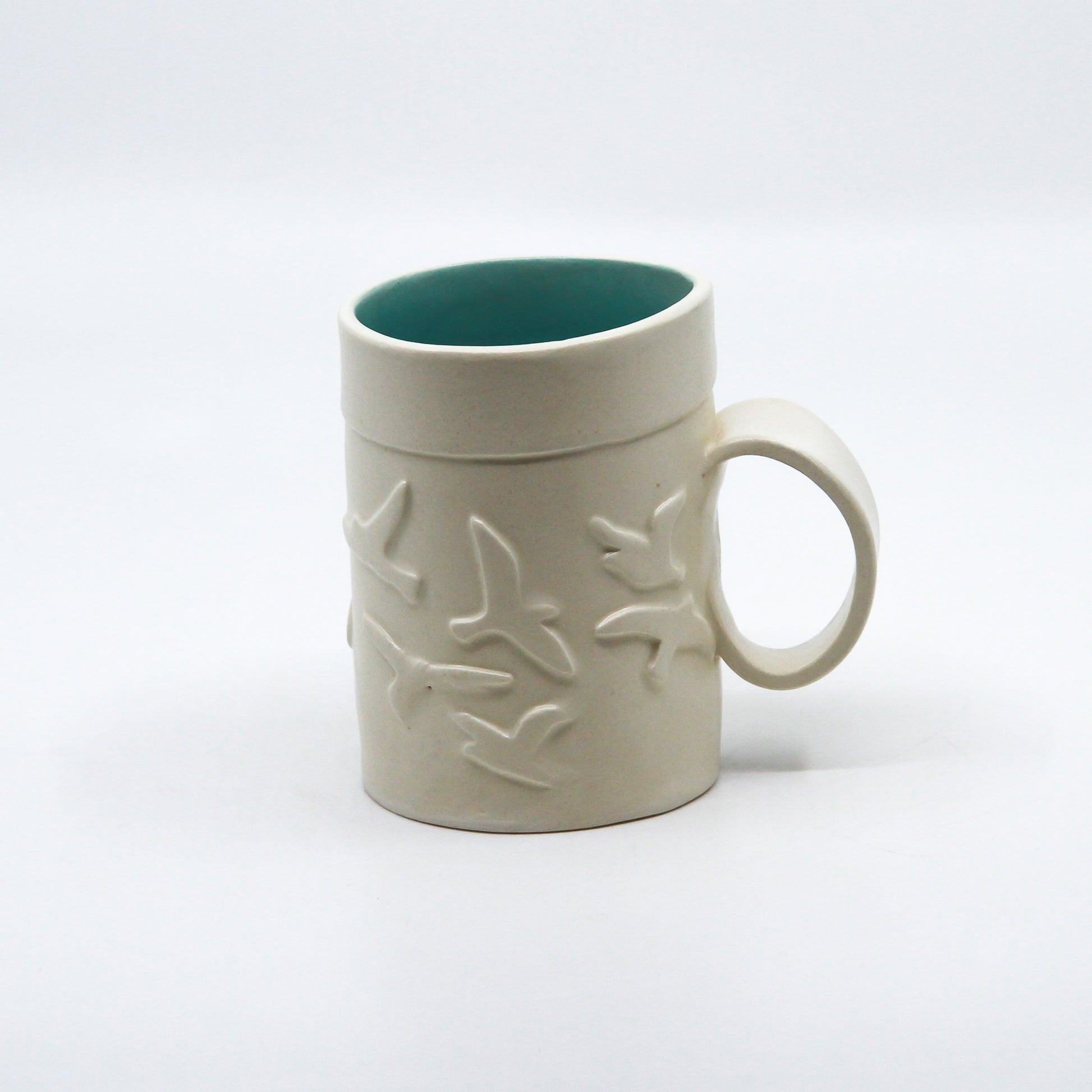 White mug with birds and turquoise inside