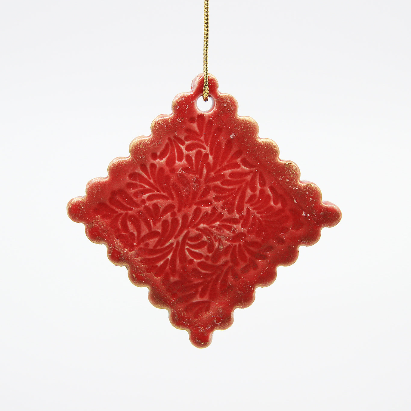 Red diamond clay Christmas ornament with carved pattern and scalloped edges, dusted with gold luster