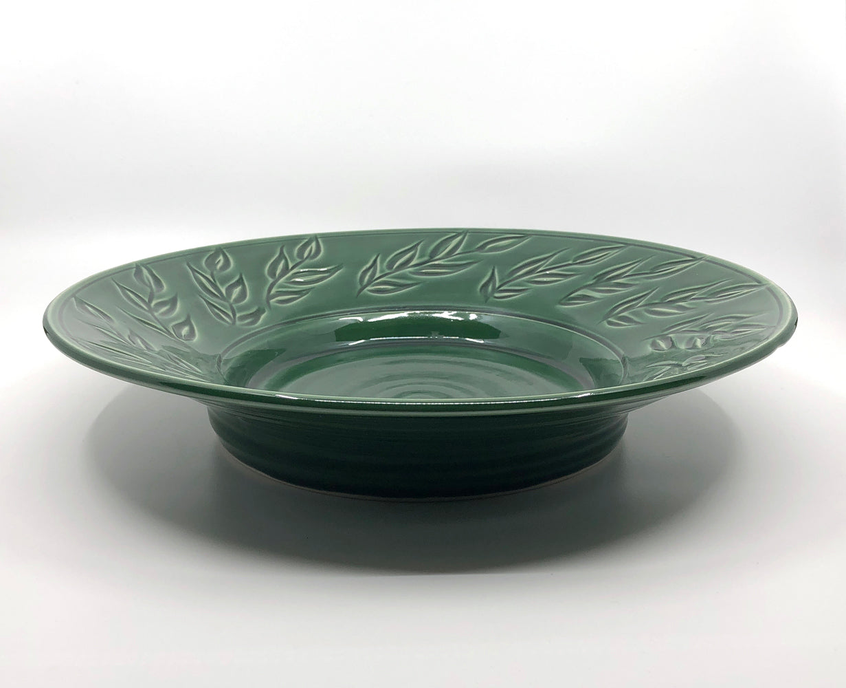 Green bowl with carved leaf pattern on rim