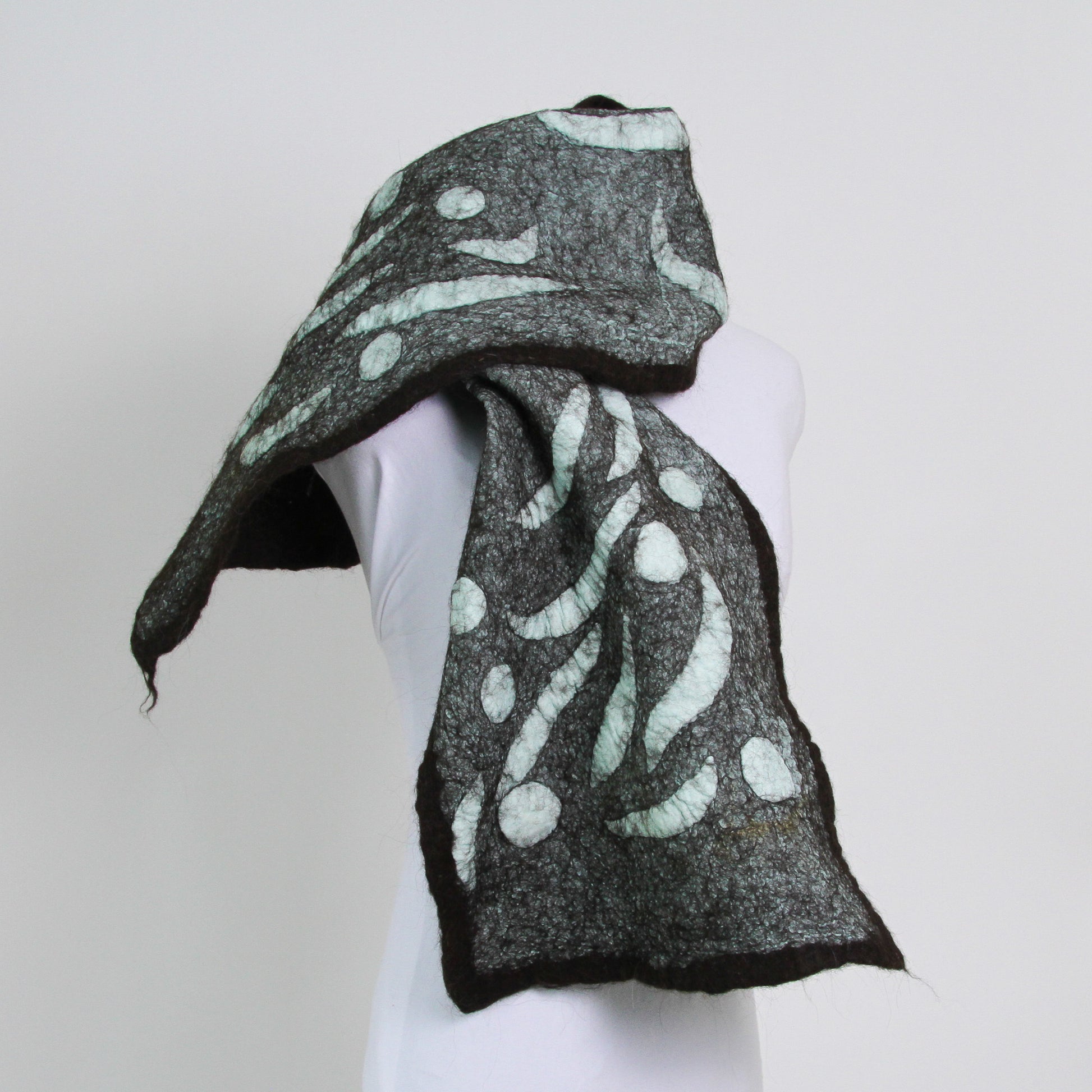 Teal scarf with abstract shapes trimmed with dark brown.