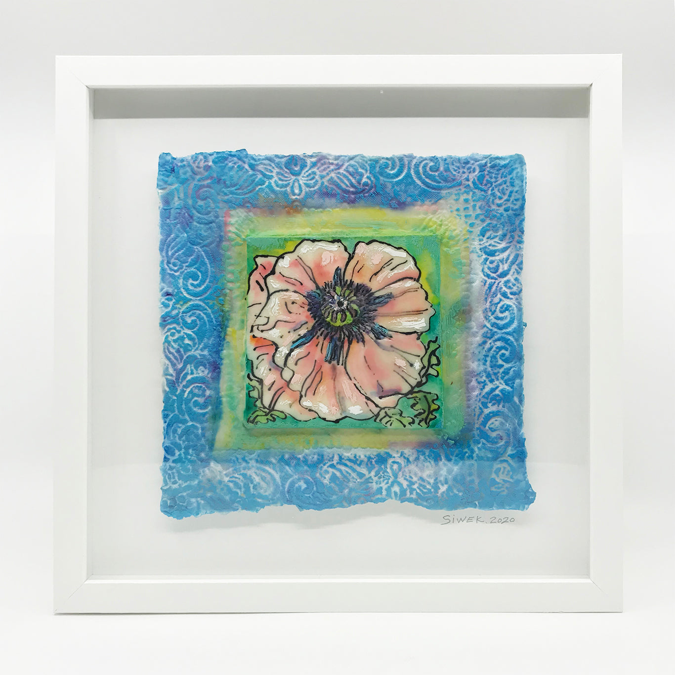 Encaustic of a ale pink poppy framed by blue handmade paper