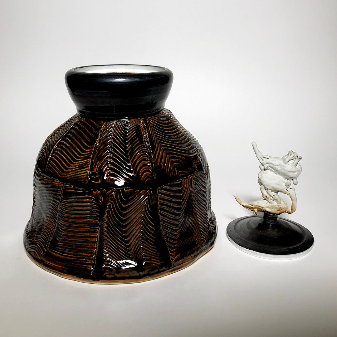 Brown and black vase with bandicoot lid