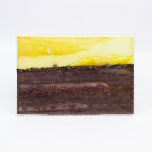 Yellow sky with moon, brown fields