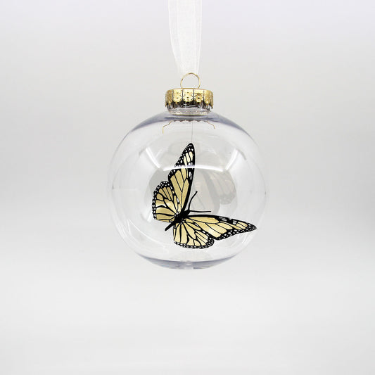 Golden monarch butterfly in a clear Christmas bauble