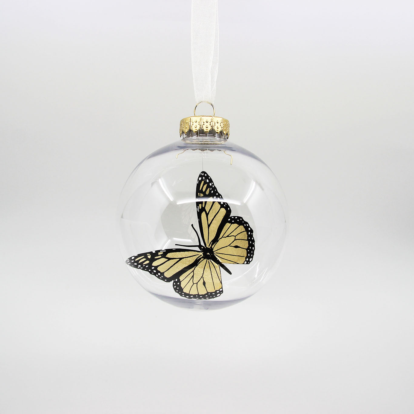 Golden monarch butterfly in clear Christmas bauble