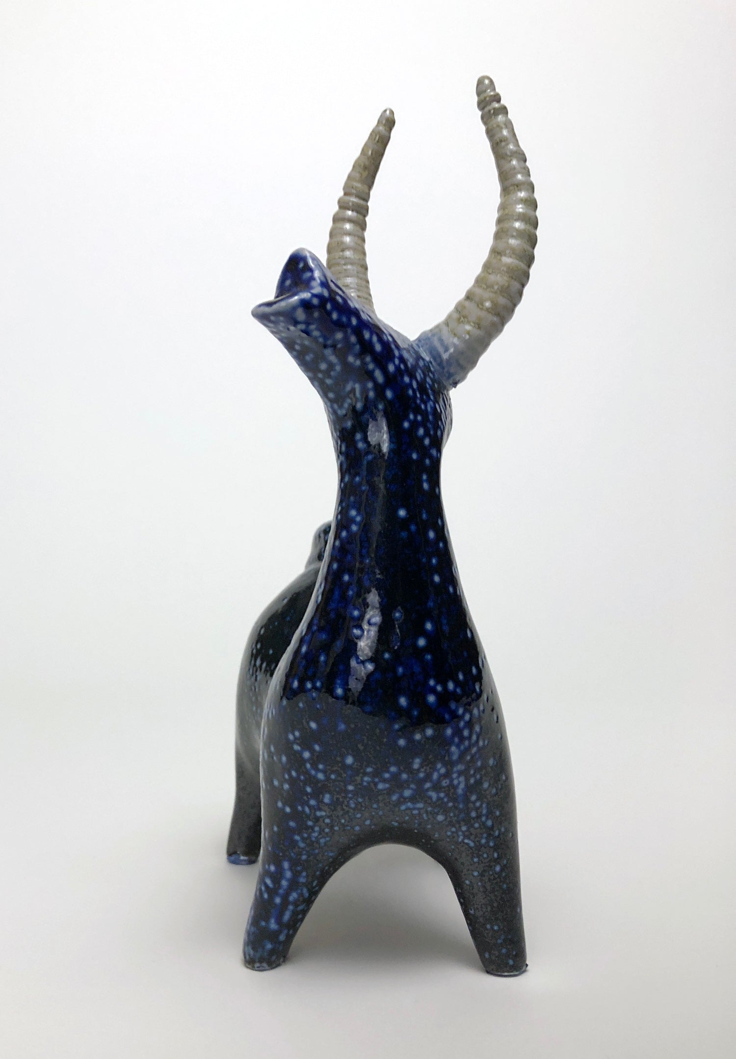 Clay statue of a blue stag speckled with white