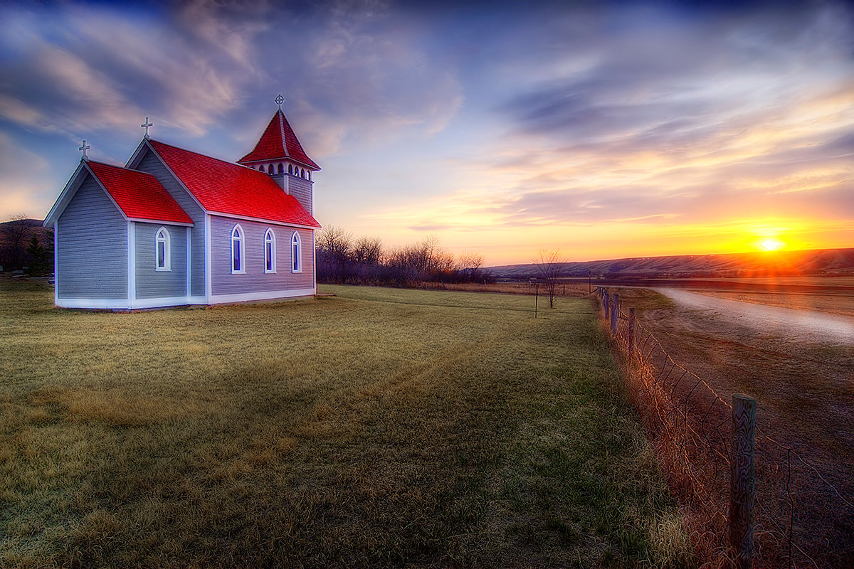 Photograph of a red roofed church in a sunset