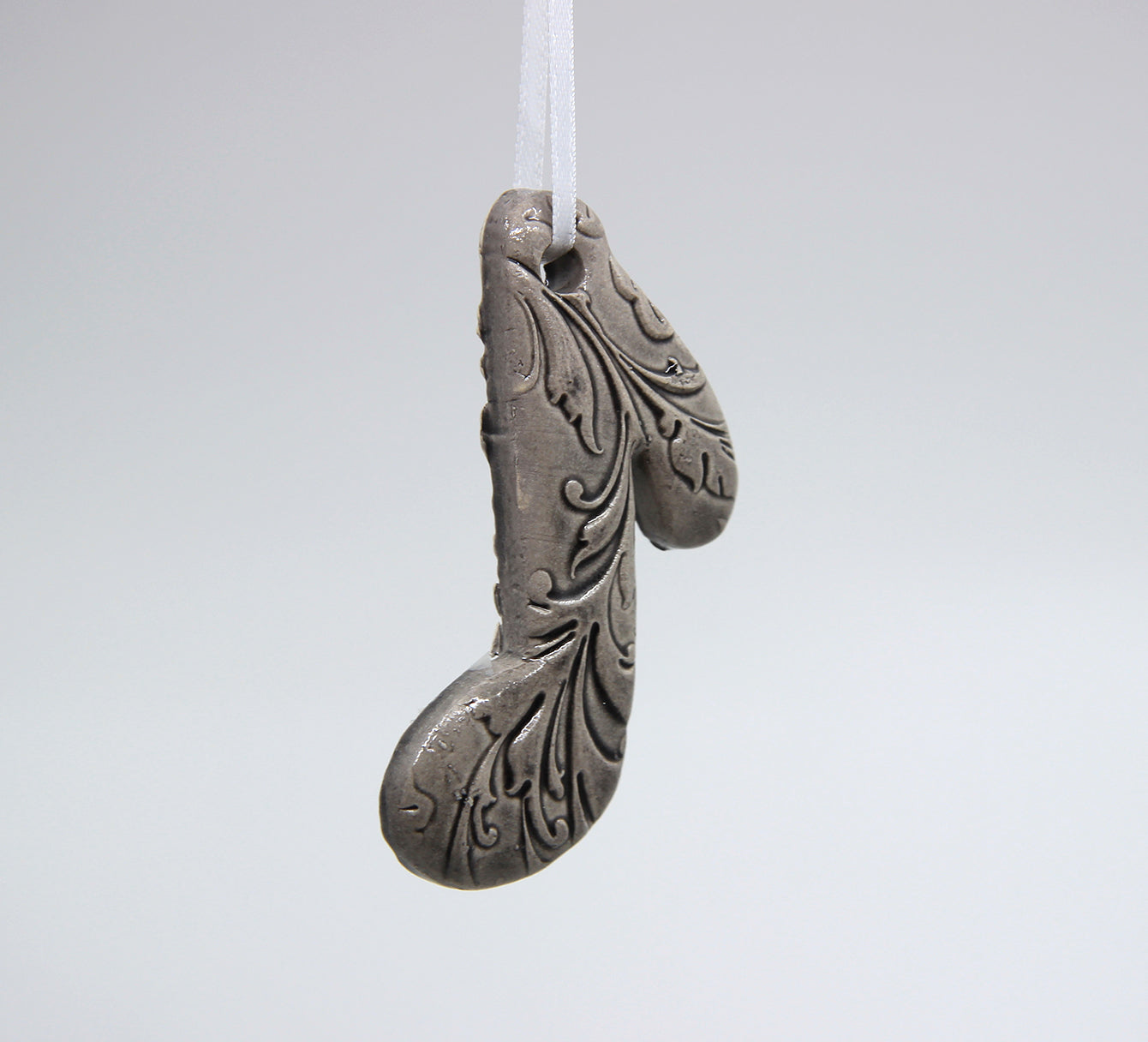 grey eighth note embossed with baroque floral pattern