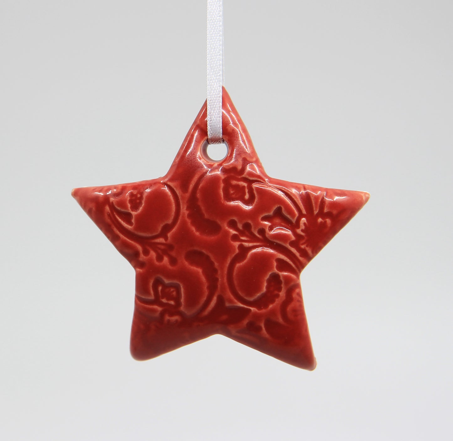 Red star ornament embossed with floral pattern