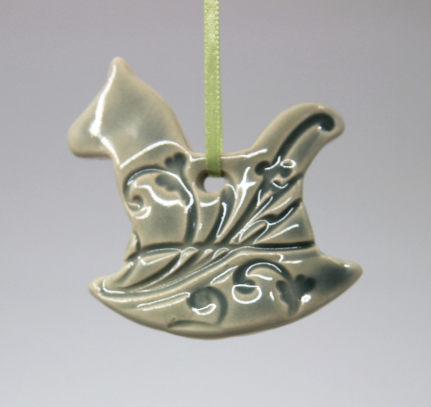 Green rocking horse embossed with floral pattern