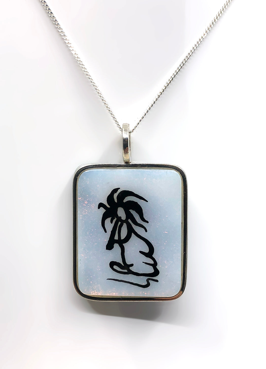 Glass pendant of a mythical creature. the kokopelli
