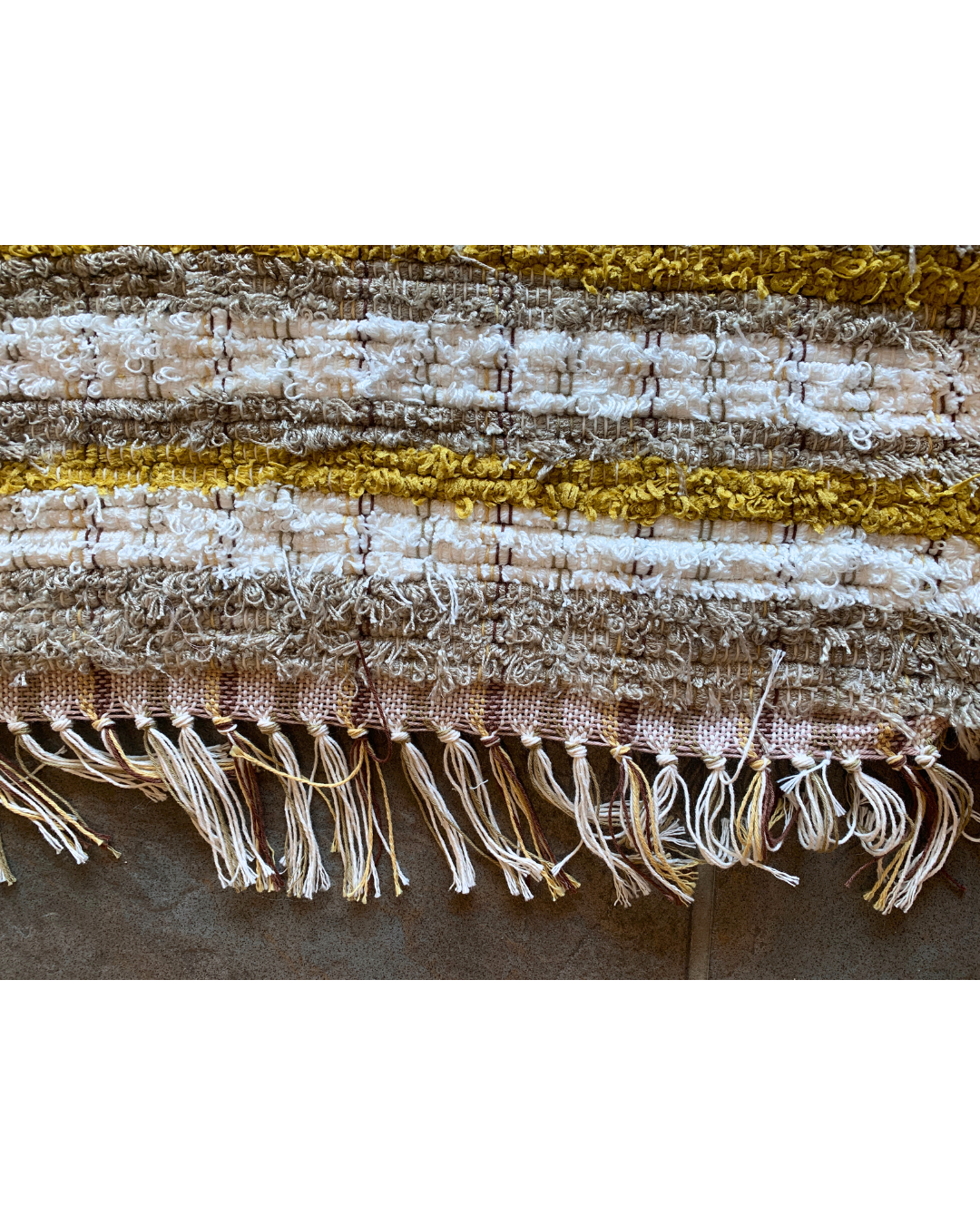 detailed view of a Brown, white and mustard woven fringe rug 