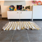 A Brown, white and mustard woven fringe rug laying in front of a cabinet