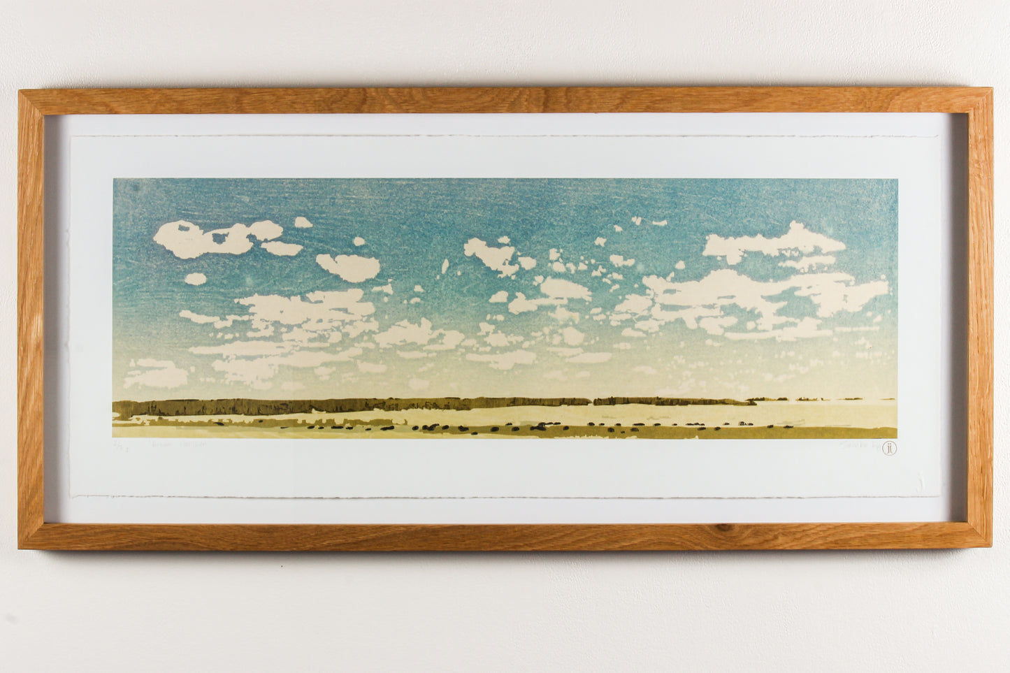 Framed wood print landscape of a blue sky and a field of grazing bison.