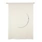 A large white wall hanging, featuring a grey embroidered image of a thin crescent moon.