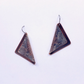 A pair of triangular drop earrings with a dark reddish-brown frame and a textured, patterned silver-toned center, hanging from simple metal fishhook wires on a plain white background.