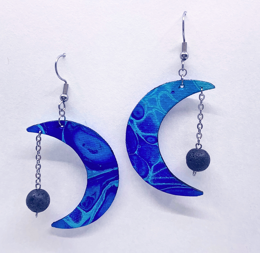 Blue marbled crescent moon earrings with spherical beads on a white background