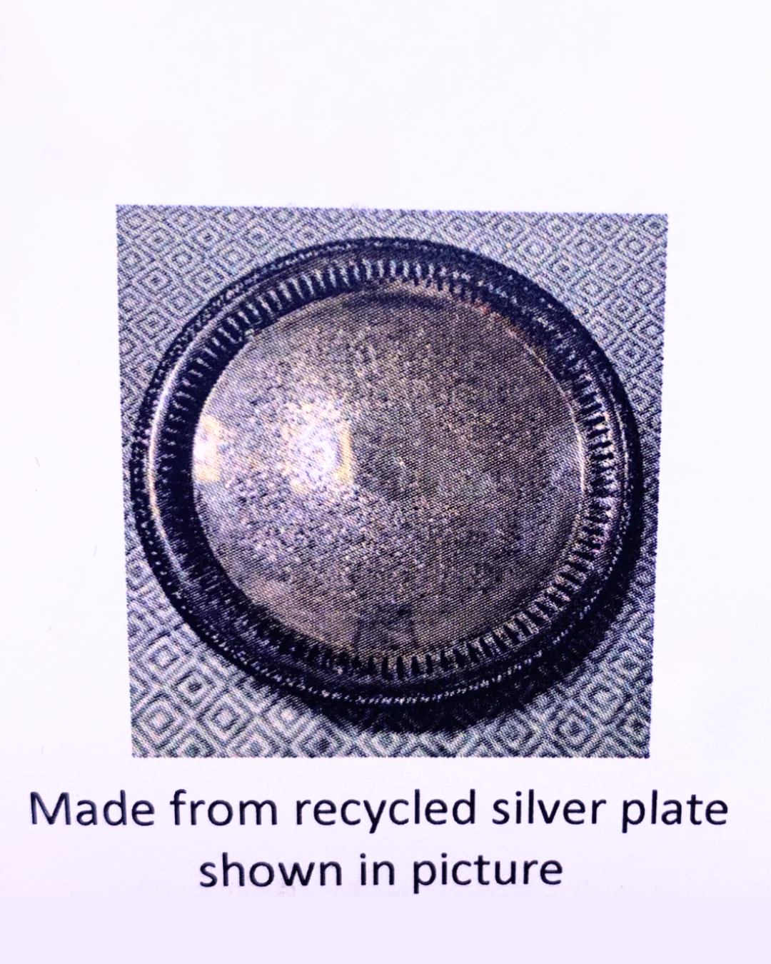 A round silver-coloured metal plate with a textured, recycled finish and a decorative beaded rim, shown on a patterned background with text below reading 'Made from recycled silver plate shown in picture'.