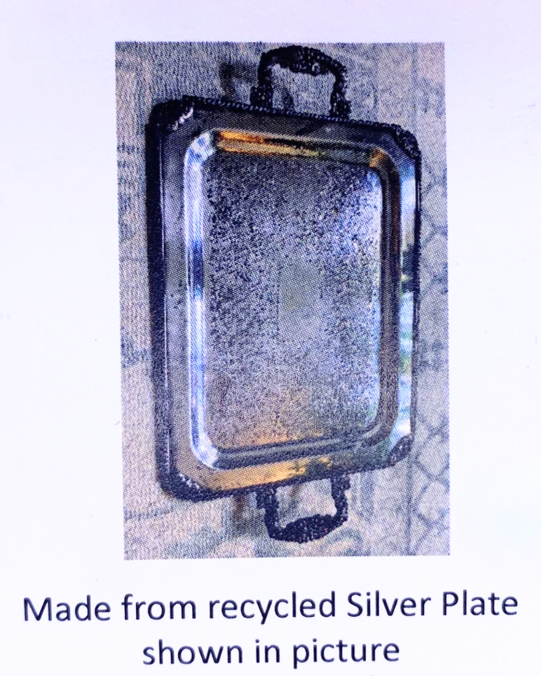 A square metal tray with rounded corners and two dark handles, shown on a light background with text below reading 'Made from recycled Silver Plate shown in picture'.