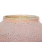 Close up shot of a round ceramic vessel. The mouth is smooth and symmetrical, with bubbly pink glaze on the outside.